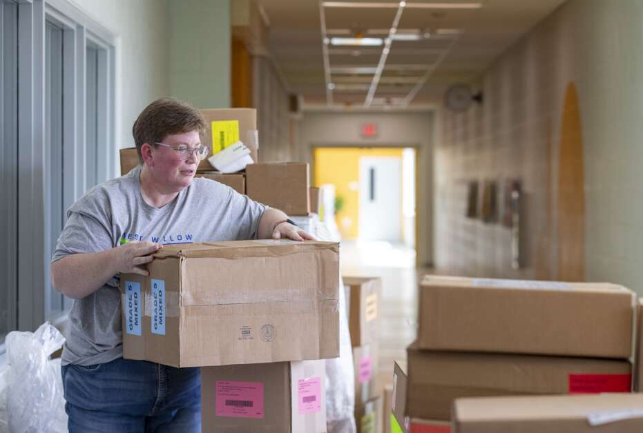 Media secretary Nicole Day sorts through hundreds of boxes of new curriculum April 19 at West Willow Elementary School in Cedar Rapids. (Savannah Blake/The Gazette)