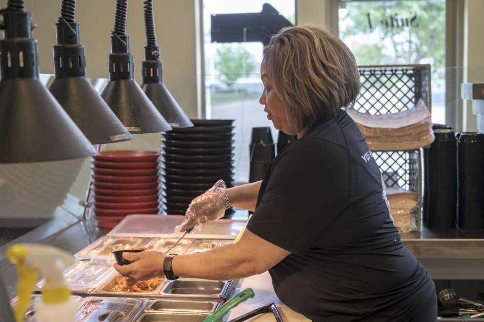 Carol Cater-Simmons prepares an order Thursday at the restaurant she and her husband own, Sugapeach Chicken & Fish Fry in North Liberty. The restaurant hopes to negotiate down a roughly $65,000 fine from the U.S. Department of Labor. (Nick Rohlman/The Gazette)