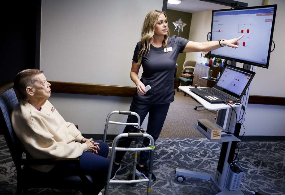 Doctor of Physical Therapy and Director of Rehab Services Amanda Rose goes over the results of a gait analysis to resident Margaret Selzer as she demonstrates the system at West Ridge Care Center in northwest Cedar Rapids on May 8. The VSTBalance system uses artificial intelligence and machine vision to identify deficits in balance, gait, and function: three indicators of fall risk. The analysis helps Rose tailor a care plan to strengthen balance, gait, and function. (Jim Slosiarek/The Gazette)