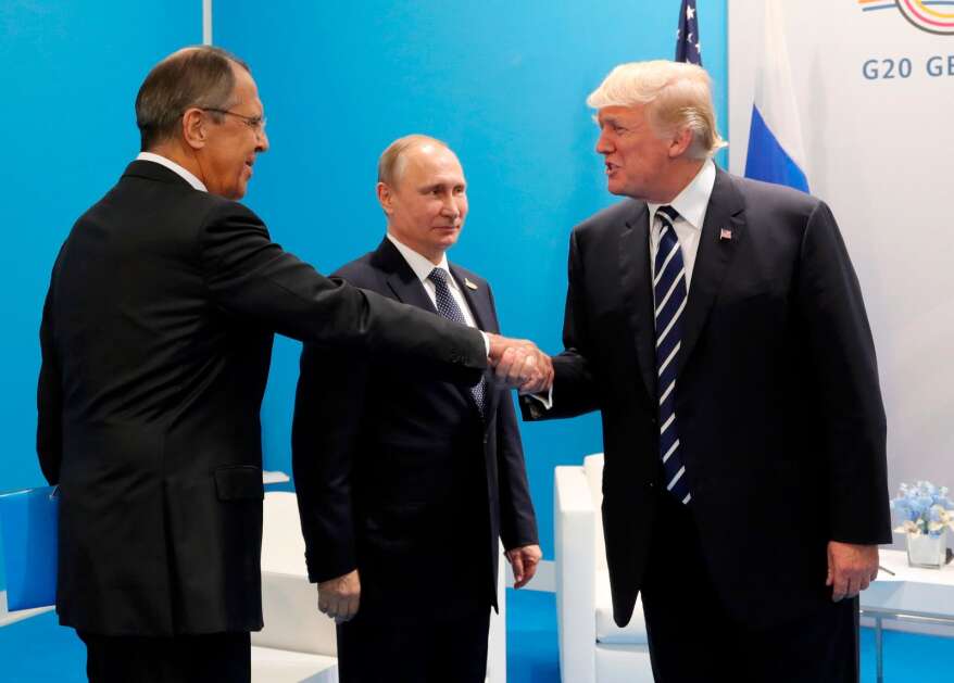 FILE - U.S. President Donald Trump, right, greets Russian Foreign Minister Sergey Lavrov, left, prior his talks with Russian President Vladimir Putin, center, during the G20 summit in Hamburg Germany in July 7, 2017. In his role for nearly 18 years, Lavrov, 71, has seen relations with the West shift from near-friendly to openly hostile, plummeting to a catastrophic new low with the Russian war against Ukraine. The invasion prompted the European Union to freeze the assets of both Putin and Lavrov, among others — an unprecedented blow to Moscow's pride. (Mikhail Klimentyev, Kremlin Pool Photo via AP, File)