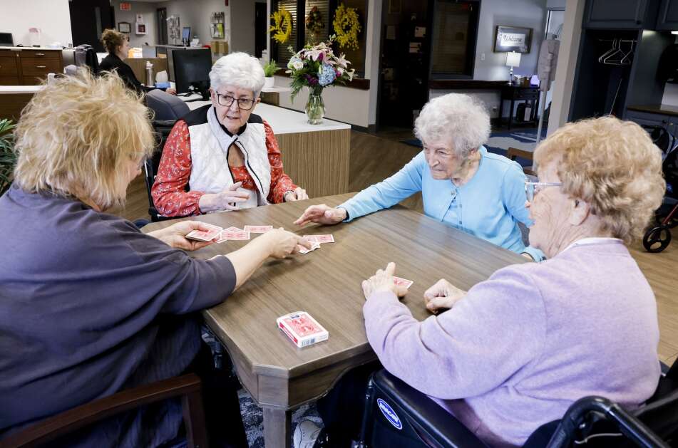 Eden mentor Carol Ruggles (left) deals cards to (clockwise from top) Pam Zedrick, Marie Sigwarth and Eleanor VanTasell as they play rummy at West Ridge Care Center in northwest Cedar Rapids on May 8. (Jim Slosiarek/The Gazette)