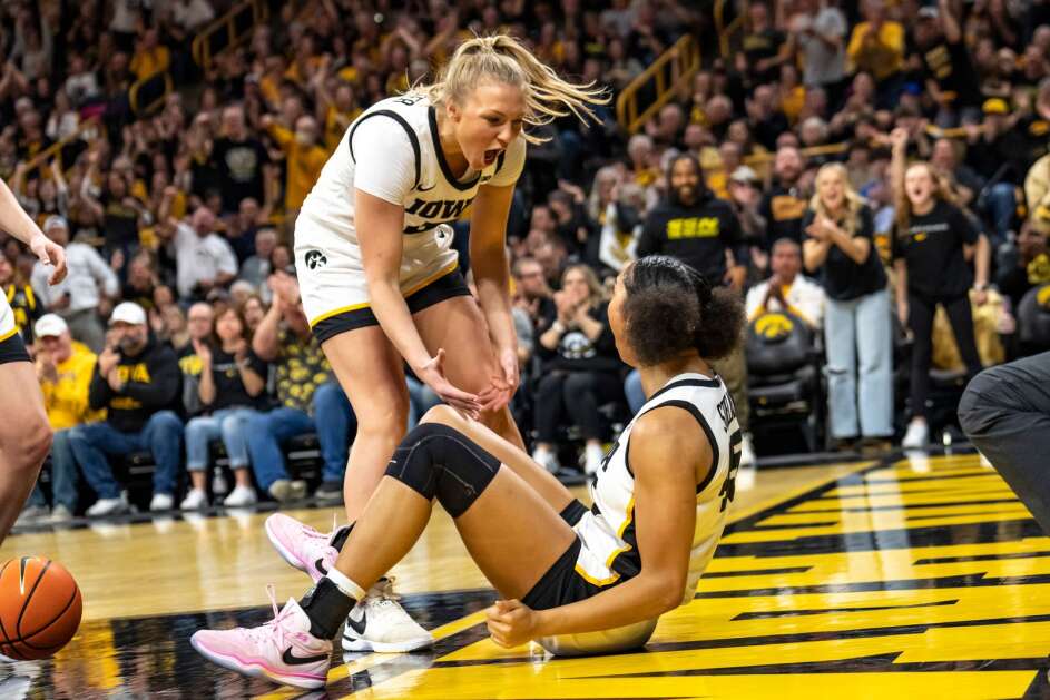 Sydney Affolter (3) helps up teammate Hannah Stuelke after Stuelke made a shot and drew a foul in Iowa’s 93-83 win over Ohio State on Sunday at Carver-Hawkeye Arena. Affolter will join the starting lineup at the Big Ten tournament this week in the absence of Molly Davis, who is out with a knee injury. (Geoff Stellfox/The Gazette)