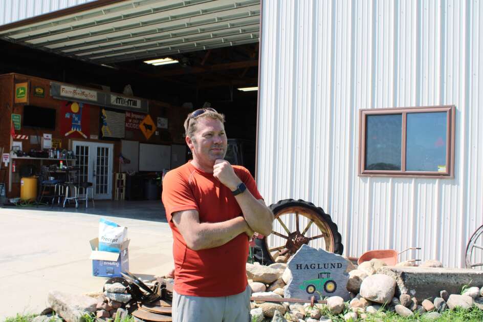 Mental health advocate Jason Haglund stands outside a machine shed on his family's farm near Boone on May 17. He has seen how farmers' traditional self-sufficiency can make them hesitant to seek help for mental stress. (Tony Leys/KFF Health News)