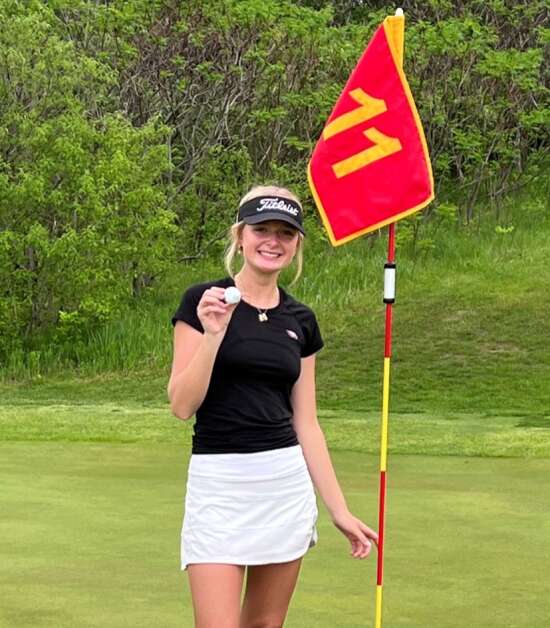 Cedar Rapids Prairie senior Morgan Burhans poses with the flag and the golf ball after acing the No. 11 hole during the Mississippi Valley Conference Mississippi Division meet Monday, May 13, 2024, at Airport National Golf Course in Cedar Rapids. It was her first hole-in-one. (Photo courtesy of Erik Columbus)