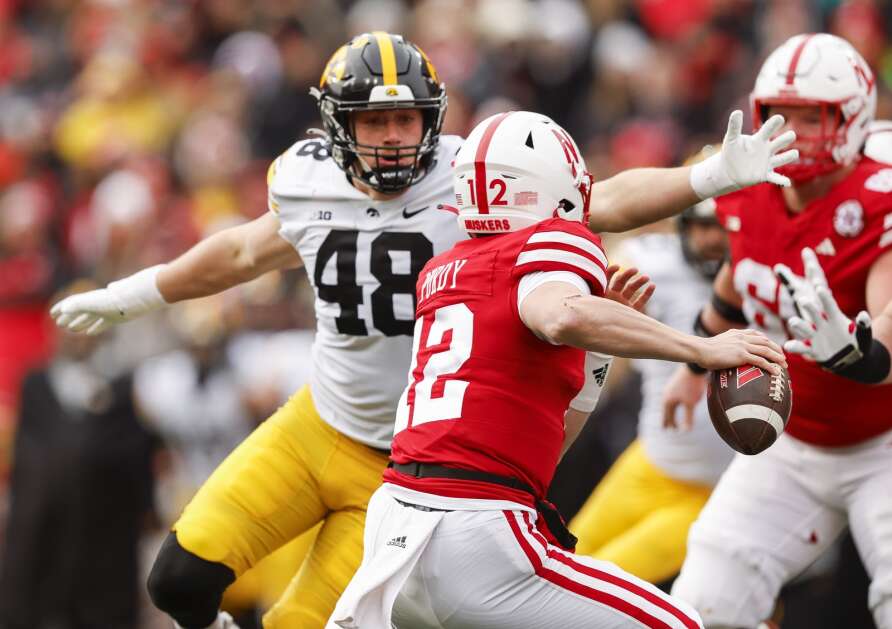 Nebraska Cornhuskers quarterback Chubba Purdy (12) scrambles from Iowa Hawkeyes defensive lineman Max Llewellyn (48) during the first half of their Big Ten Conference football game at Memorial Stadium in Lincoln, Neb., on Friday, November 24, 2023. (Jim Slosiarek/The Gazette)