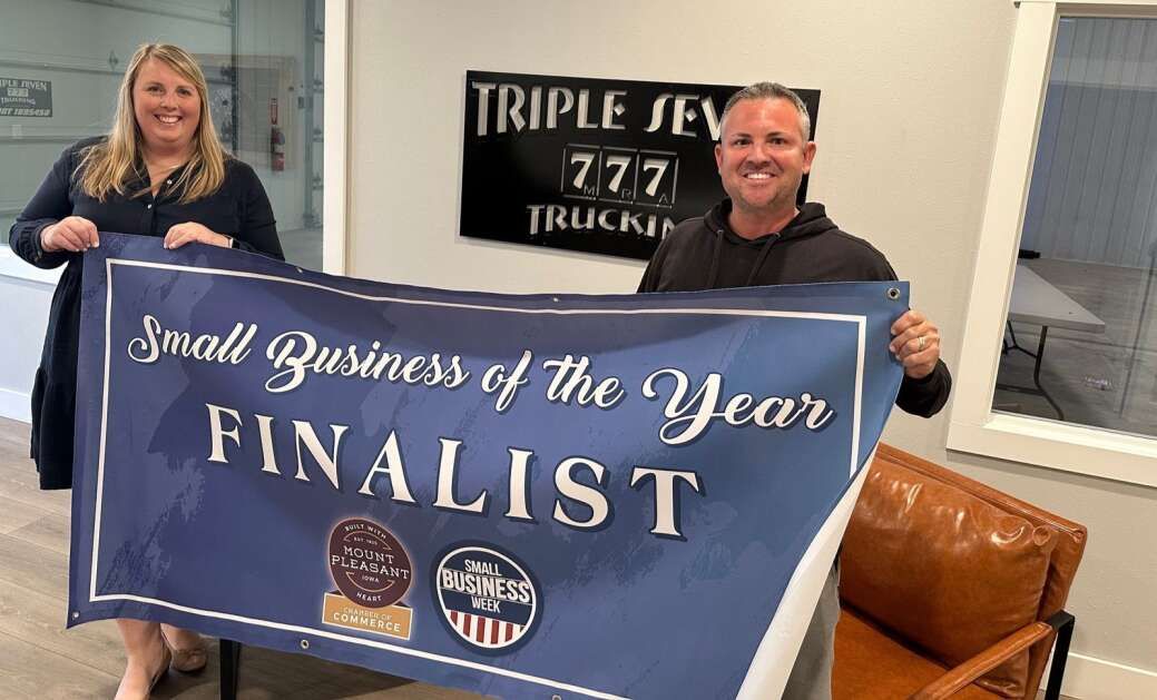 Mt. Pleasant Area Chamber of Commerce Executive Vice President Rachel Lindeen and Triple Seven Trucking Owner Blaire Barton proudly display a finalist banner at the company’s new shop opened just last year. (Photo Submitted)