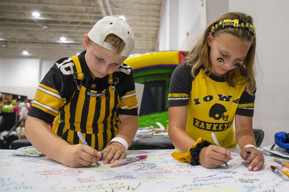 Cameron Baxter, 9, and his sister Leah Baxter, 10, of Coralville sign a birthday card for Herky during FRYFest at Iowa River Landing in Coralville, Iowa on Friday, September 1, 2023. This year’s celebration will be held Aug. 30. (Savannah Blake/The Gazette)