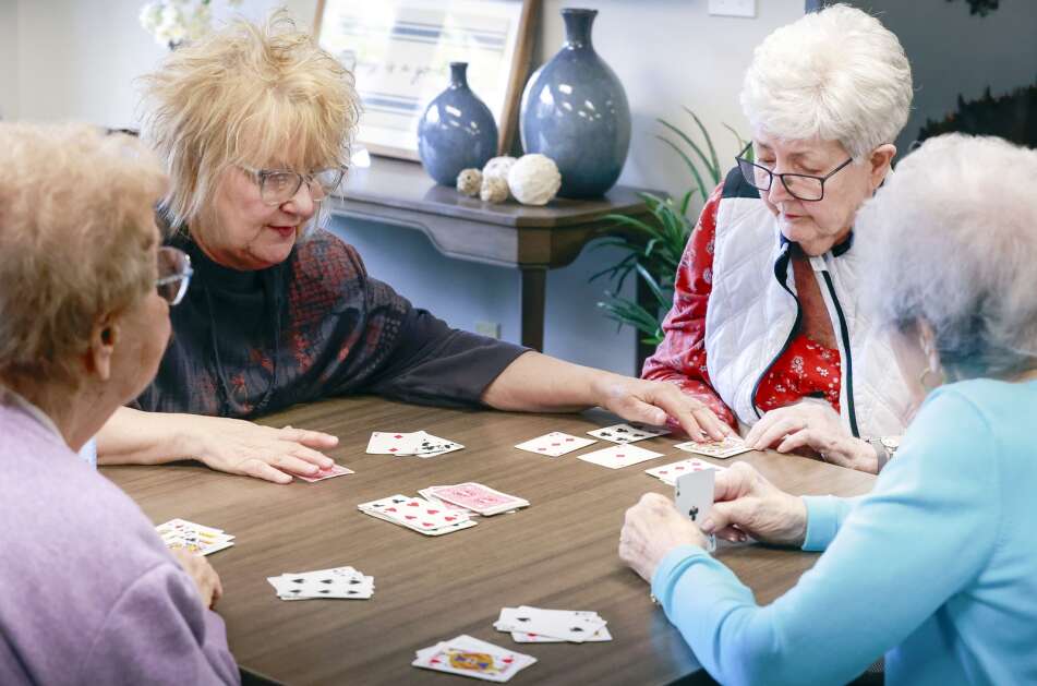 Eden mentor Carol Ruggles (second from left) helps Pam Zedrick (second from right) score her hand as they play rummy with Marie Sigwarth (right) and Eleanor VanTasell (left) at West Ridge Care Center in northwest Cedar Rapids on May 8. (Jim Slosiarek/The Gazette)