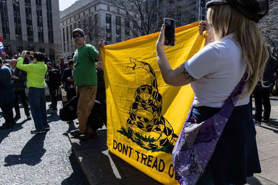 Trump supporters holding a Gadsden flag at protest across the street from the Manhattan District Attorney's office in New York in April 2023. The flag, which has become a symbol of individual liberty favored by Libertarians and conservatives, could become a new Iowa license plate design available to vehicle owners.  (AP Photo/Stefan Jeremiah)