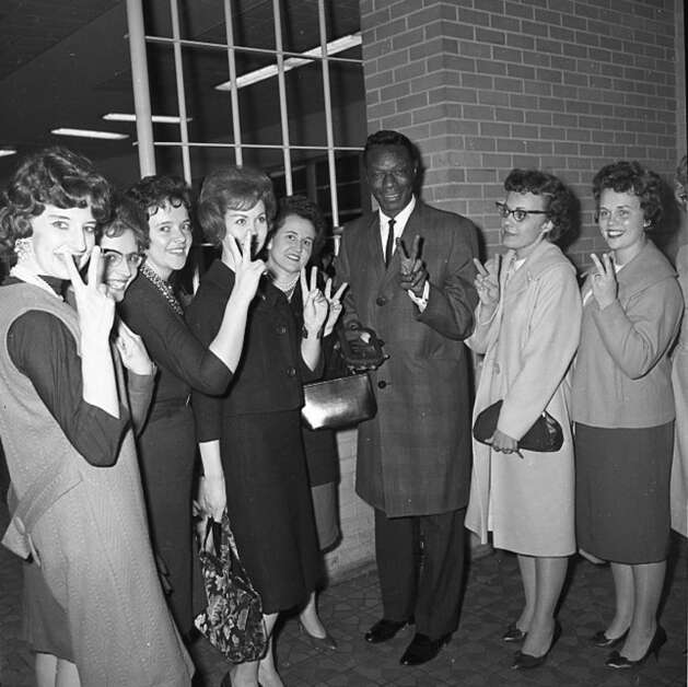 Members of the Twin Club of Cedar Rapids flank singer Nat King Cole Nov. 19, 1963, in Cedar Rapids after presenting him with a plaque signifying honorary membership in the club. (Gazette archives) 