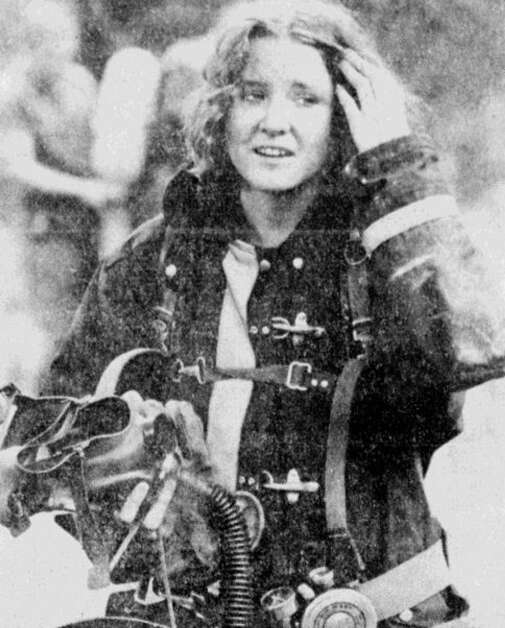 Pushing sweaty hair out of her face, Gazette reporter Ann Schrader begins removing fire equipment after taking part in a fire training exercises in June 1977 with Cedar Rapids firefighters. (Gazette archives)