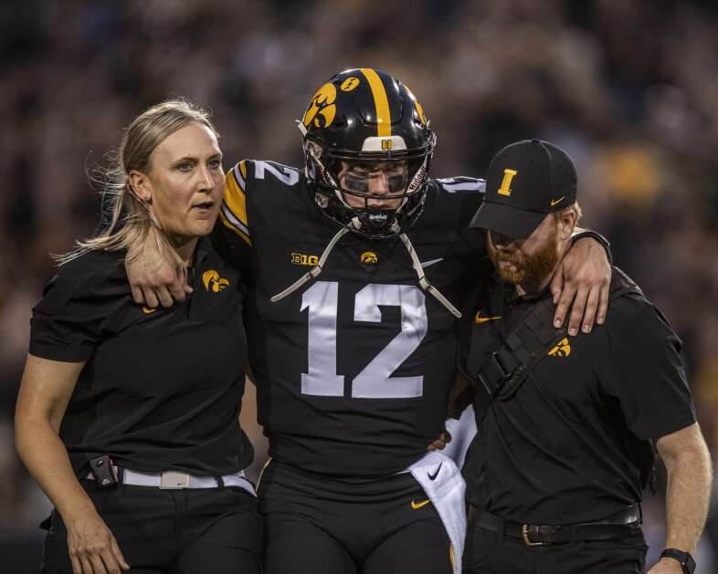 Iowa Hawkeyes quarterback Cade McNamara (12) is helped off the field after an injury during a game between the Iowa Hawkeyes and the Michigan State Spartans at Kinnick Stadium in Iowa City, Iowa on Saturday, September 30, 2023. (Nick Rohlman/The Gazette)