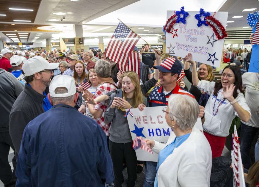 People in the crowd cheer on veterans as they return from the Honor Flight at the Eastern Iowa Airport in Cedar Rapids, Iowa on Tuesday, April 25, 2023. (Savannah Blake/The Gazette)