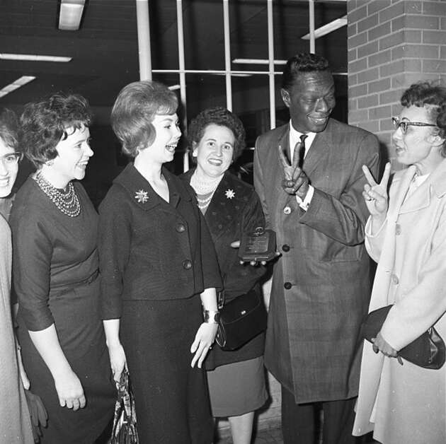 Members of the Twin Club of Cedar Rapids flank singer Nat King Cole Nov. 19, 1963, in Cedar Rapids after presenting him with a plaque signifying honorary membership in the club. (Gazette archives) 