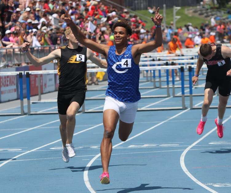 Columbus’ Triston Miller raises his hands after winning the Class 1A 110-meter hurdles at the Iowa High School Track and Field Championship. (Hunter Moeller/The Union)