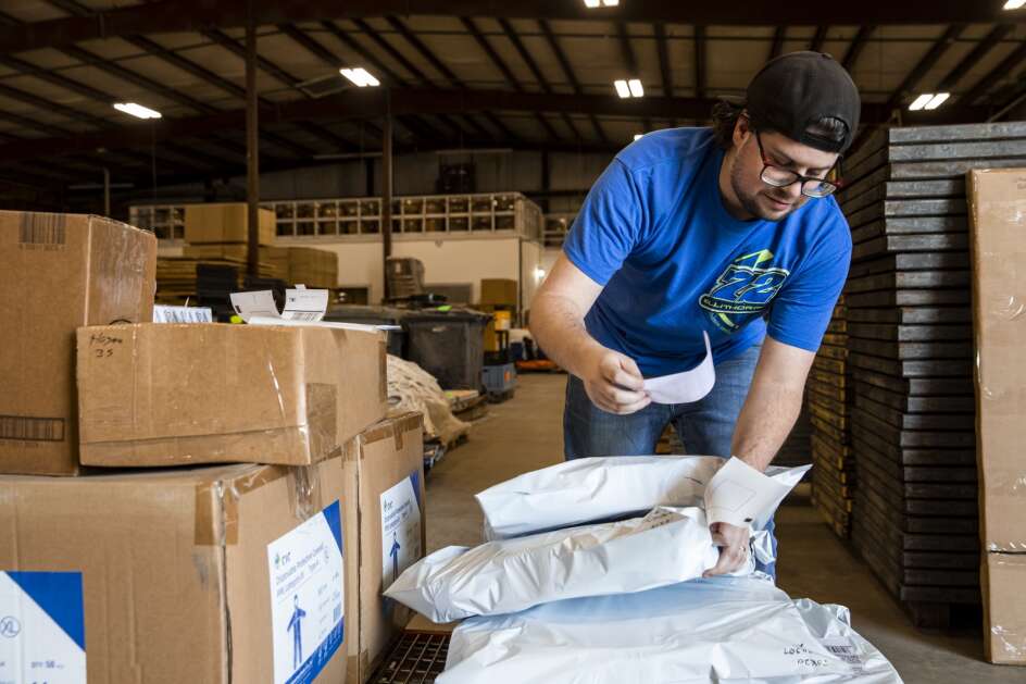 David Hayes applies shipping labels to customer orders awaiting pickup at repurposedMATERIALS’ warehouse in Maquoketa, Iowa on Friday, April 14, 2023. The company, based in Denver, Colo., purchases  industrial and building materials slated for disposal and resells then to customers who can reuse or utilize them for new purposes. (Nick Rohlman/The Gazette)
