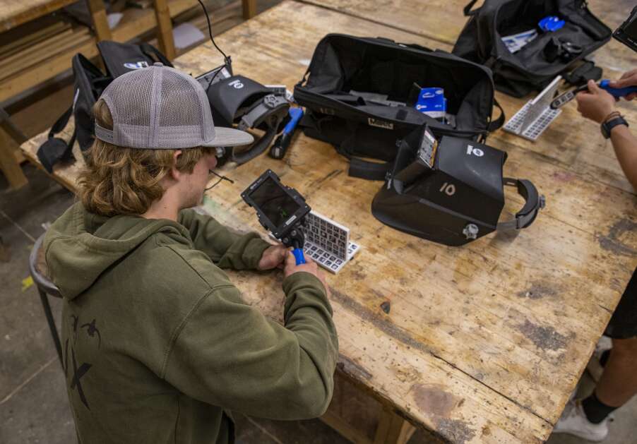 Freshman Nelson Crow uses a handheld virtual reality device to practice his welding technique during a May 9 class at Williamsburg High School. After the weld is done, students receive an accuracy score on a scale of 1 to 100. Crow consistently scored above 90 while working with the machine. (Savannah Blake/The Gazette)