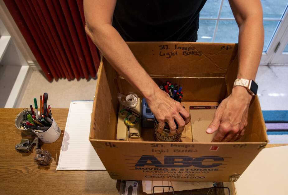 Christine Smart, owner of Designing Moves, packs a box of office supplies for a client in Iowa City on August 16.  Items that customers or their family members don't want are donated to schools or non-profit organizations.  (Savannah Blake/The Gazette)