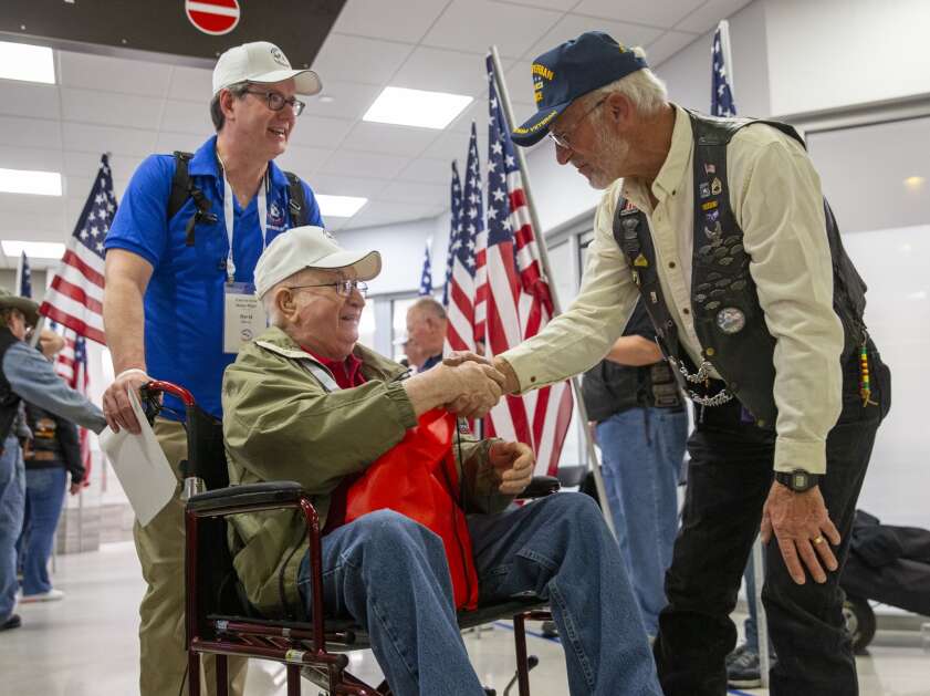 Patriot Guard Rider member Harry Hopp shakes veteran John Walderbach’s hand after his arrival at the Eastern Iowa Airport in Cedar Rapids, Iowa on Tuesday, April 25, 2023. (Savannah Blake/The Gazette)