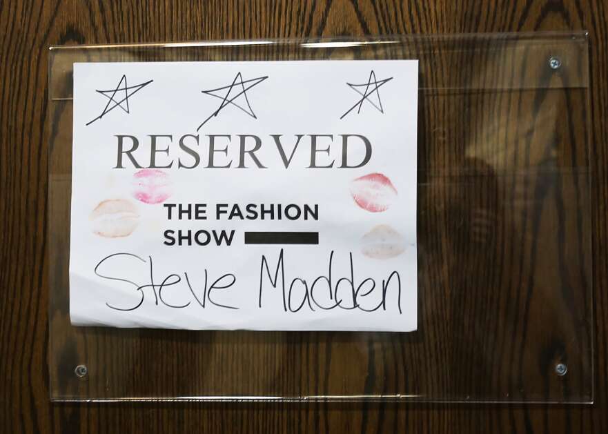 A sign covered in kisses designates where the racks of Steve Madden clothes are kept backstage April 15 at The Fashion Show at Stephens Auditorium in Ames. (Bailey Cichon/The Gazette)