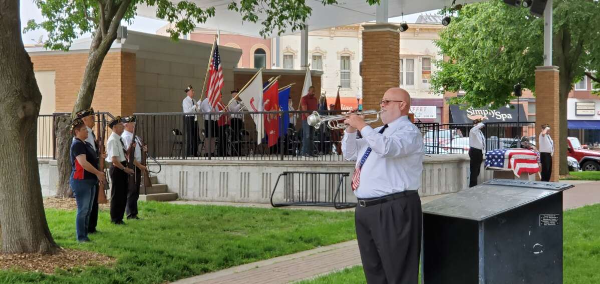 John Harris plays taps as the Honor Guard stands at attention at the end of the Memorial Day ceremony.