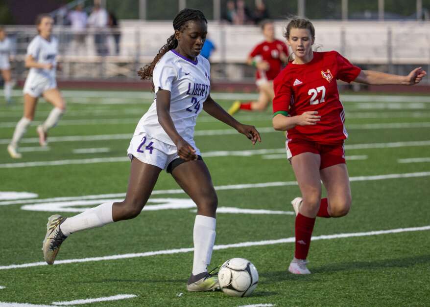 Iowa City Liberty midfielder Eno Ituk (24) drives the ball towards the Wolves goal with pressure from Marion forward Maggie Utsinger (22) in the second half of the game at Marion High School in Marion, Iowa on Thursday, May 25, 2023. (Savannah Blake/The Gazette)
