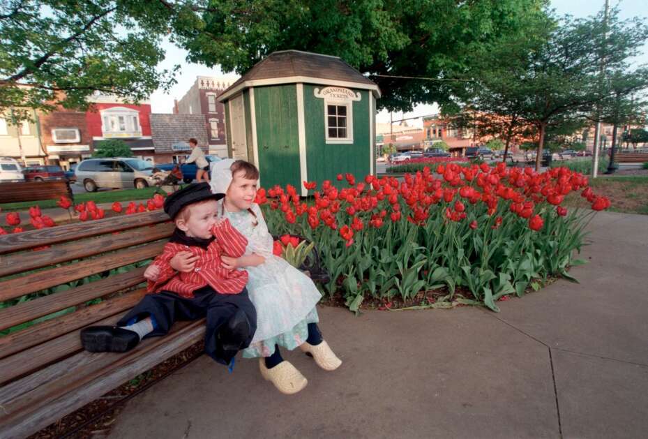 Dressed in traditional Dutch costumes, Sarah DeMoss, 5, holds her little brother, Christopher, in Pella's downtown square May 8, 2001, during the Tulip Time Festival in Pella. The popular spring festival started in 1935. (Gazette archives) 