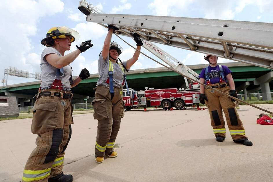 Cedar Rapids firefighter Amy Kunkle (left) guides Rylee Bolsinger, 15, of Cedar Rapids, as she raises a ladder during the CRFD Fully Involved fire academy for young women on Aug. 2l 2017, at the department's drill tower in northwest Cedar Rapids. (The Gazette)