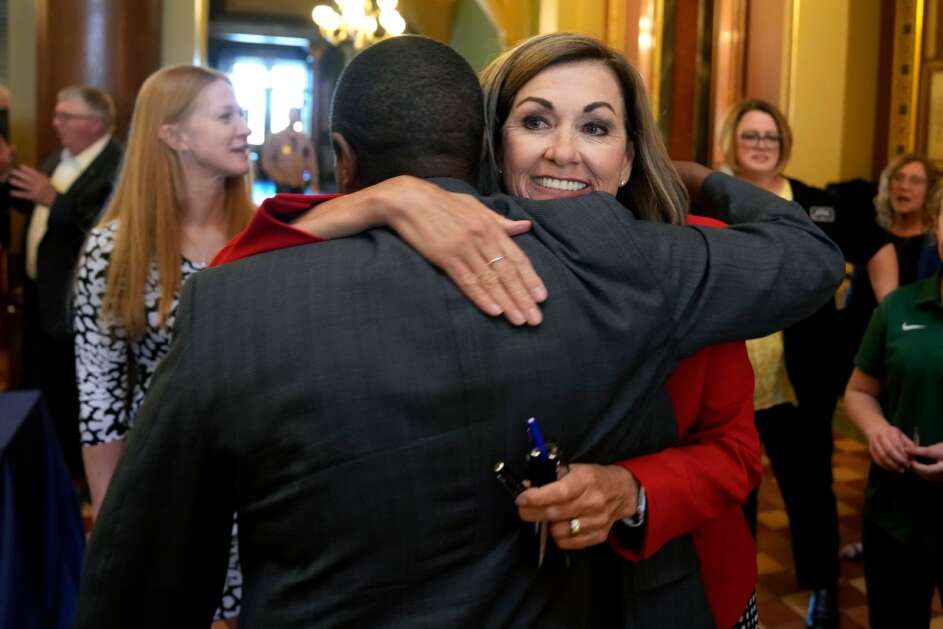 Iowa Gov. Kim Reynolds (right) gets a hug after signing a property tax cut bill Thursday at the Statehouse in Des Moines. (Charlie Neibergall/Associated Press)