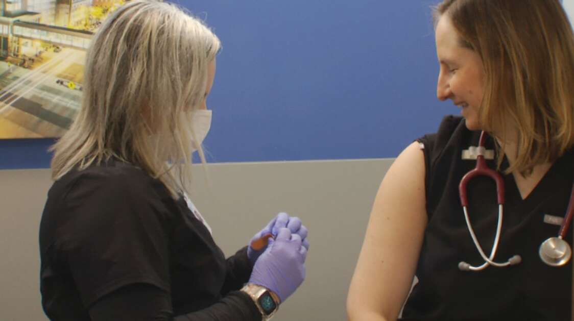 Nurse Amy Straw administers a COVID-19 booster vaccine to Dr. Amy Smolucha at the Eastern Iowa Health Center. As the federal public health emergency declaration ends, the clinic is ramping up efforts to reach populations who haven’t received their vaccine or updated booster. (Eastern Iowa Health Center)