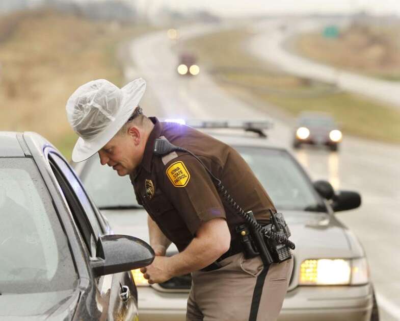 Iowa State Patrol Trooper Bob Conrad issues a warning for speeding to a motorist in April 2014 on Highway 30 west of Cedar Rapids. He said people became more comfortable driving faster during the pandemic, when fewer cars were on the road, and some haven’t slowed down now that traffic has returned to normal levels. (The Gazette) 