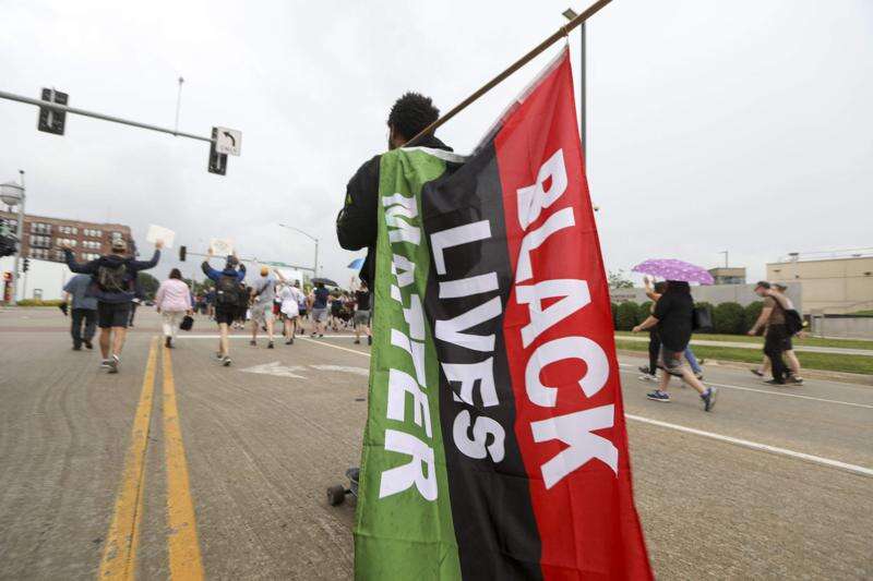 A protestor carries a sign at a march and Juneteenth gathering in Cedar Rapids on Friday, June 19, 2020. The Advocates for Social Justice announced that they reached an agreement with the City Council to work toward implementing the seven demands they had put forth in last week's meetings. (Rebecca F. Miller/The Gazette)