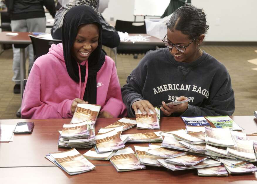 Iman Alnour, left, 15 of Iowa City, and Rayan Saad, 15 of Iowa City, laugh as they organize educational pamphlets while members of the Mariam Girls’ Club prepare for an upcoming annual World Hijab Day event at the Coralville Public Library on Saturday. The club is partnering for the second year with the library to host a public World Hijab Day event on Thursday, Feb. 1. People who attend can learn about the hijab and women in Islam. “We are organizing this event to bring awareness, to foster personal freedom of religious expressions, and to dismantle bigotry, discrimination, and prejudice against Muslim women and girls wearing the hijab” said Viana Qadoura, founder and director of the Mariam Girls Club, a group that offers young Muslim women an empowering and safe space in the Iowa City area. (Cliff Jette/Freelance)