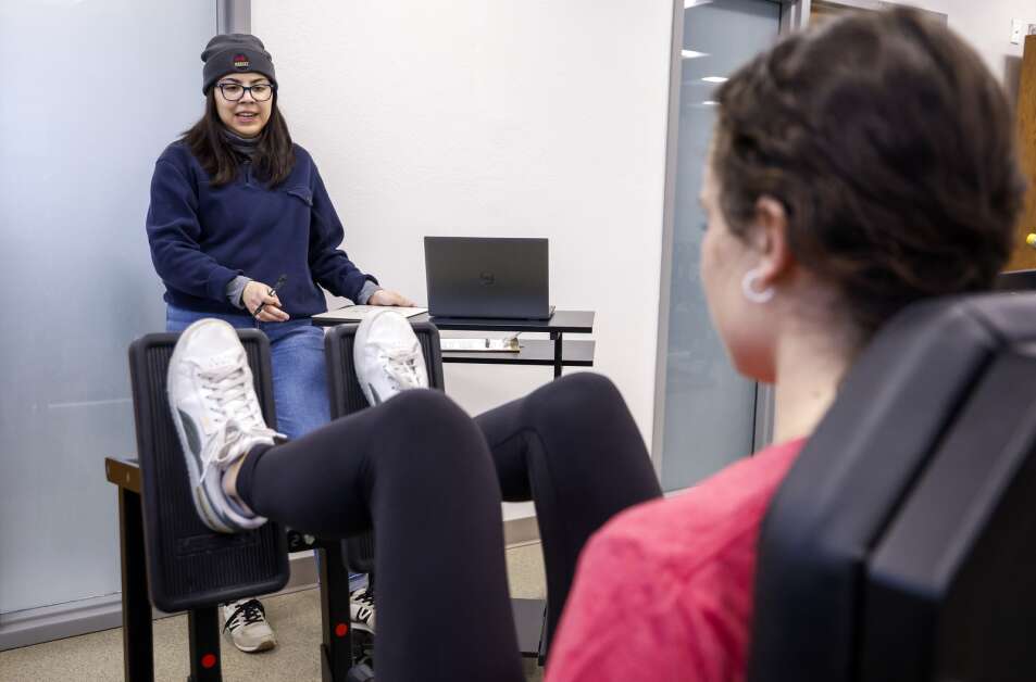 Project coordinator Abigail Molina (left) works Thursday with fellow project coordinator Abigail Burkhart, playing the role of a research participant, to determine baseline on the leg press exercise machine during a familiarization session for a research study at Iowa State University. Project coordinators took part in the sessions to practice their knowledge of the exercise equipment and administering the study’s exercises with the participants. Researchers are investigating the impact of exercise on depression. (Jim Slosiarek/The Gazette)