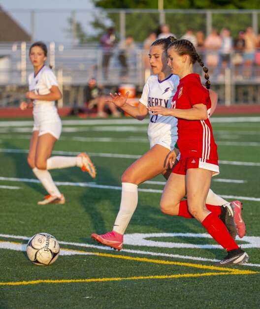 Iowa City Liberty midfielder Layla Rouse (21) runs to stop Marion forward Maggie Utsinger (22) as she drives the ball towards the Lightning goal in the second half of the game at Marion High School in Marion, Iowa on Thursday, May 25, 2023. (Savannah Blake/The Gazette)