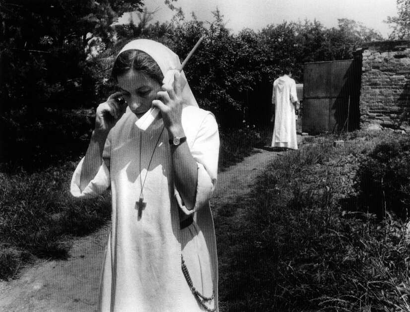 A Czech nun talks on a cordless telephone, illustrating how technology merged with tradition in Czechoslovakia after the fall of communism. The photo was part of an exhibit titled "People from the Olomouc Region," on view at the National Czech & Slovak Museum & Library in Cedar Rapids in 2000. Exhibit photos were taken by Jindrich Streit between 1993 and 1994, the period of rapid change that followed the Velvet Revolution in 1989. (Jindrich Streit)