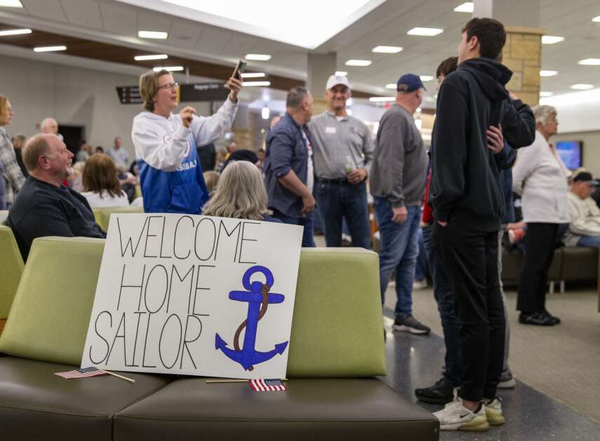 A “Welcome Home Sailor” sign sits on a bench at the Eastern Iowa Airport in Cedar Rapids, Iowa on Tuesday evening while hundreds of people wait for the arrival of the veterans on the Honor Flight. (Savannah Blake/The Gazette)