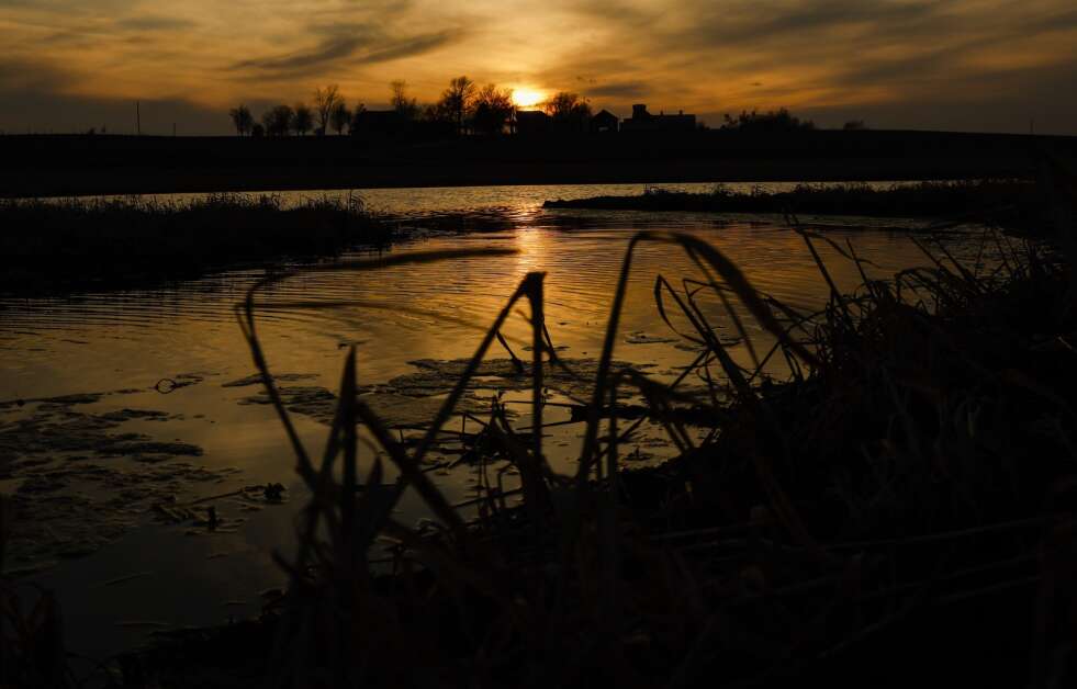 The setting sun reflects off the water March 21 of a settling basin on an over-7-acre wetland in Palo. (Jim Slosiarek/The Gazette)