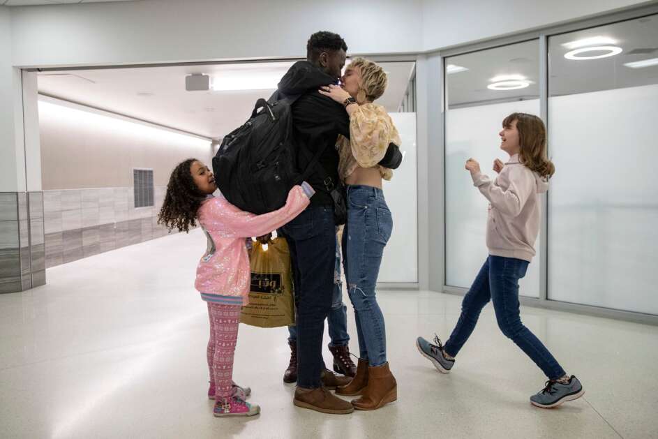 Mohamed Ahmed is greeted by his wife, Jacy Bunnell-Ahmed, daughter Layla (left), 6, and step-daughter Sacha Bunnell, 10, on Tuesday, May 2, 2023, at the Eastern Iowa Airport in Cedar Rapids, Iowa. Ahmed was stranded in Sudan for nearly two weeks as the country’s ongoing civil war damaged the Khartoum airport, preventing flights from leaving the country. After fleeing to Egypt, Ahmed was able to return to the United States. (Geoff Stellfox/The Gazette)