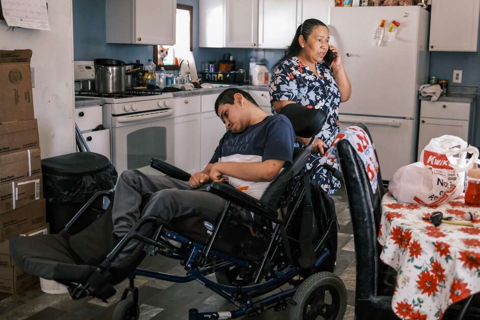 Maria Davila Hererra speaks with an immigration attorney April 12 at her home in Iowa City while caring for her son, Christian Davila Reconco, 20, who was born with physical and developmental disabilities. (Geoff Stellfox/The Gazette)