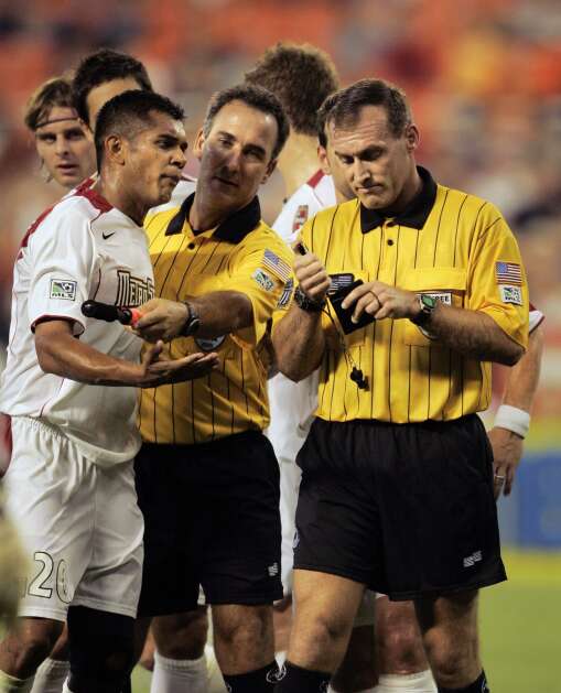 New York/New Jersey MetroStars midfielder Amado Guevara reacts to referee Terry Vaughn, right, after receiving a red card in an MLS game against DC United at RFK Stadium in Washington Wednesday, August 10, 2005. (AP Photo/Gerald Herbert)