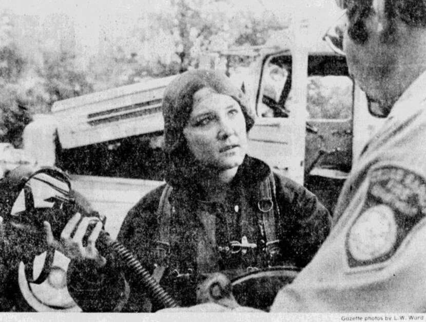 A Cedar Rapids firefighter gives Gazette reporter Ann Schrader instructions on how to use the breathing apparatus and mask in June 1977, a few months after Davenport hired the first career female firefighter in the state. The reporter took part in firefighter training during a controlled burn. (Gazette archives)