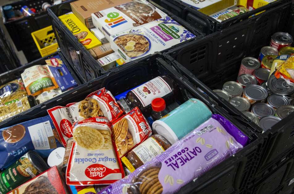 Dry goods wait to be added to the shelves May 16 at the CommUnity Food Bank in Iowa City. The food in the black boxes came from a food drive and will last the bank only a week or two, due to the need in the area. (Savannah Blake/The Gazette)