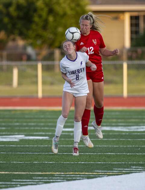Iowa City Liberty midfielder Callie Stanley (8) and Marion defender Sydney Fox (12) both try to head the ball in the second half of the game at Marion High School in Marion, Iowa on Thursday, May 25, 2023. (Savannah Blake/The Gazette)