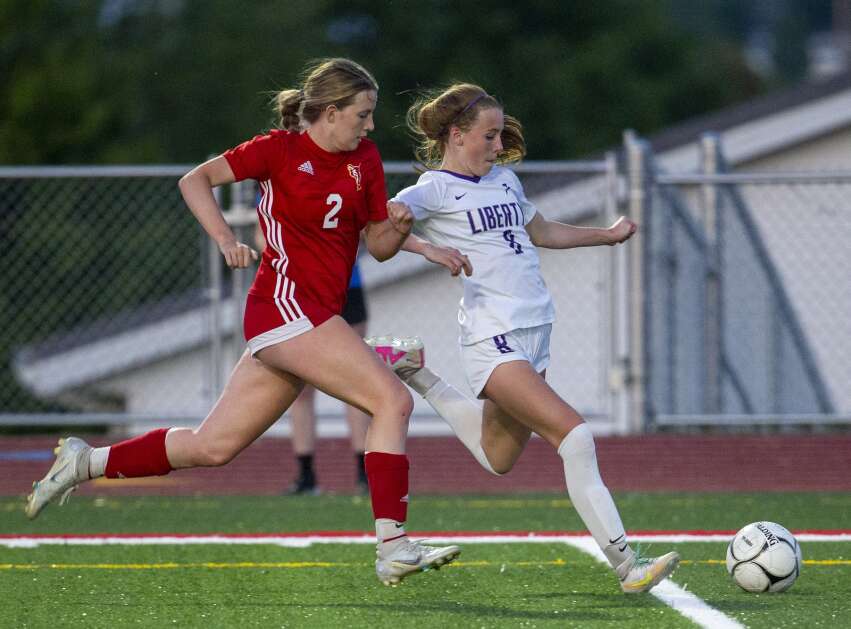 Marion defender Katelyn Allison (2) runs to block Iowa City Liberty midfielder Callie Stanley (8) as she kicks the ball towards the Wolves goal in the second half of the game at Marion High School in Marion, Iowa on Thursday, May 25, 2023. (Savannah Blake/The Gazette)