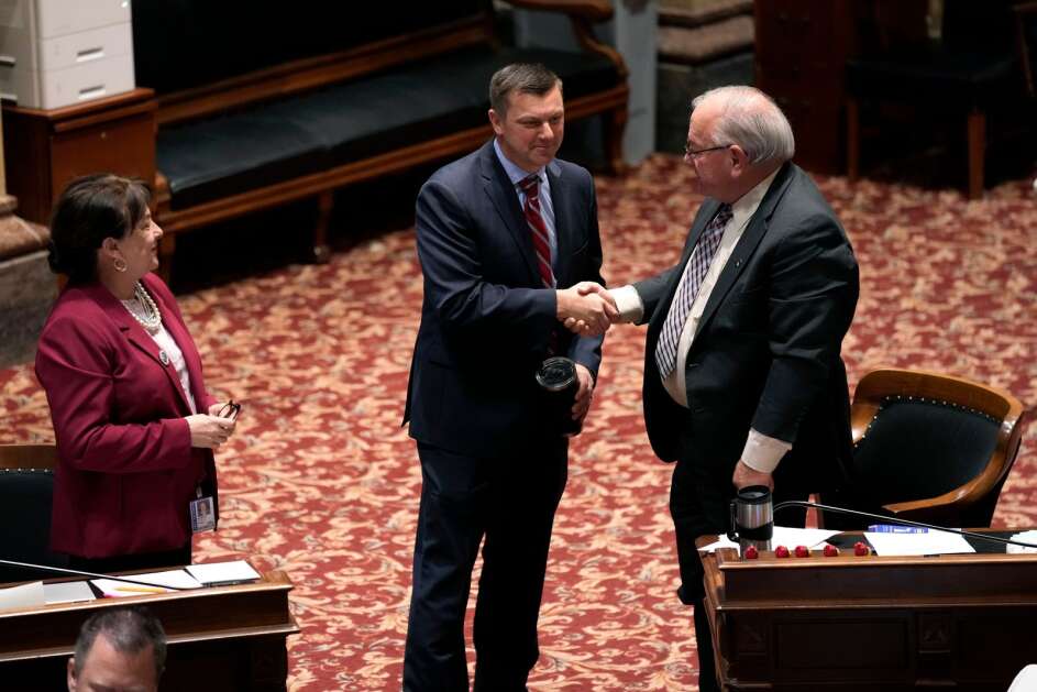 Iowa Senate Majority Leader Jack Whitver (center)  greets Sen. Tom Shipley, R-Adams, in the Iowa Senate on Thursday, the last day of the 2023 legislative session, at the Statehouse in Des Moines. (Associated Press)