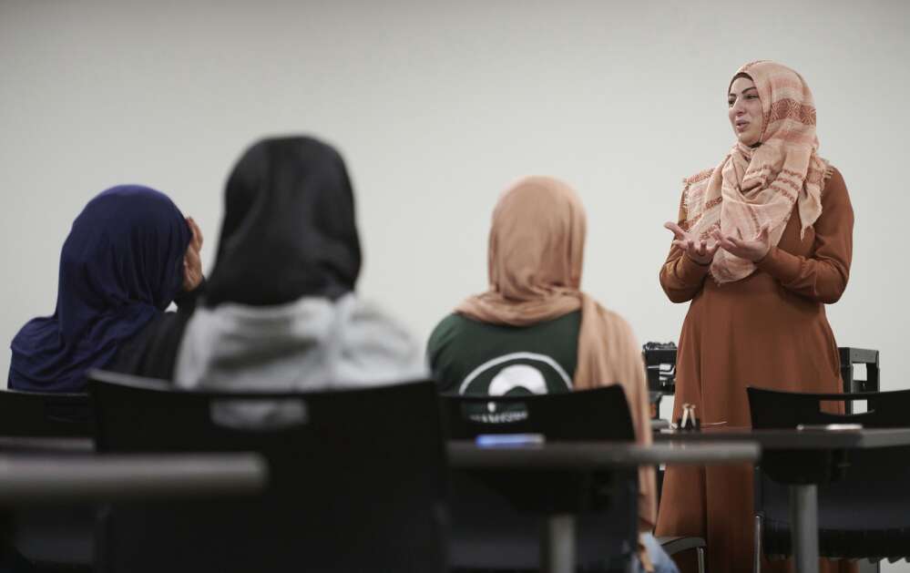 Viana Qadoura, founder and director of the Mariam Girls’ Club, speaks to club members about the role of modest dress and behavior for men and women in Islam during a meeting to prepare for an upcoming annual World Hijab Day event at the Coralville Public Library on Saturday, January 27, 2024. The club is partnering for the second year with the library to host a public World Hijab Day event on Thursday, February 1 at 4:30pm where participants can learn about the hijab and women in Islam. “We are organizing this event to bring awareness, to foster personal freedom of religious expressions, and to dismantle bigotry, discrimination, and prejudice against Muslim women and girls wearing the hijab” says  Qadoura. (Cliff Jette/Freelance)