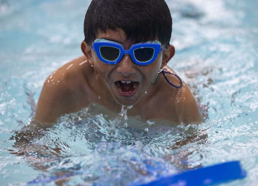 Cedar River Academy second grader Rafael Perez takes a breath of air as he practices his kicks and breathing underwater during an April 11 swim lesson at Bender Pool in Cedar Rapids. (Savannah Blake/The Gazette)