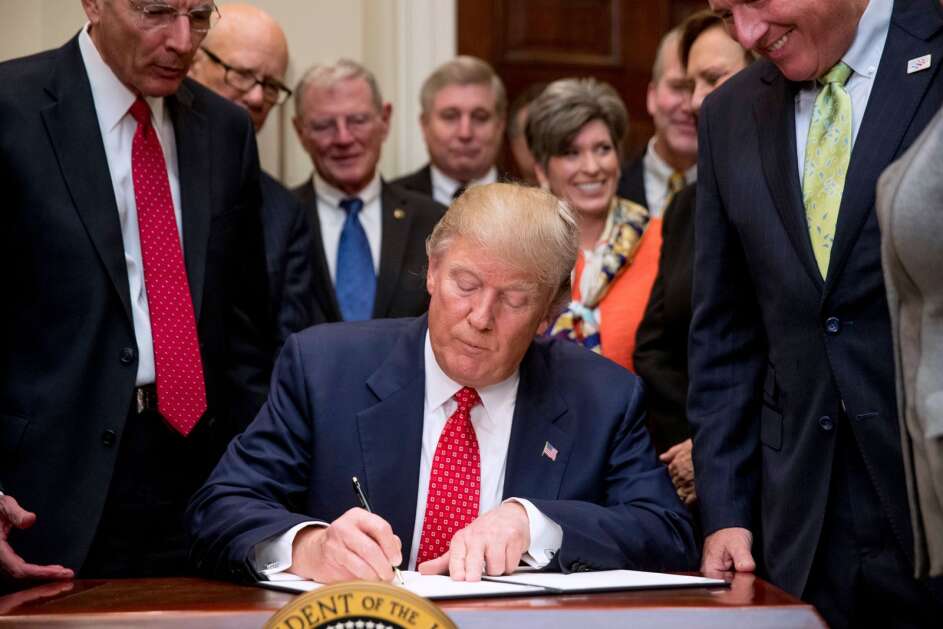 President Donald Trump signs the Waters of the United States (WOTUS) executive order, Tuesday, Feb. 28, 2017, in the Roosevelt Room in the White House in Washington, which directs the Environmental Protection Agency to withdraw the Waters of the United States (WOTUS) rule, which expands the number of waterways that are federally protected under the Clean Water Act. (AP Photo/Andrew Harnik)