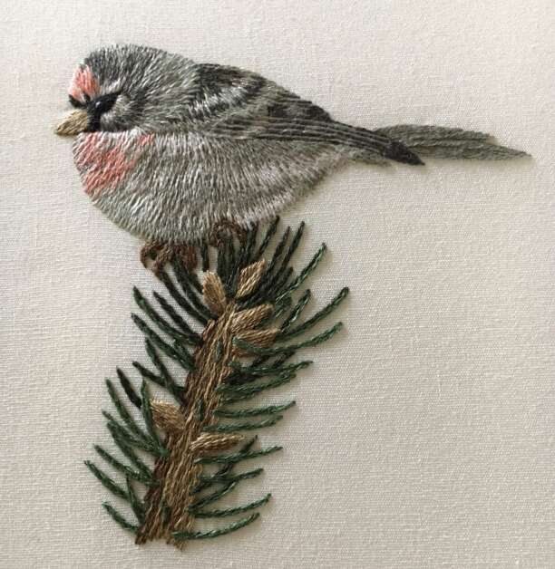 This little bird is one of Sheri Ekstrom's  examples of needle painting, with subtle color variations and a brush stroke feel to the stitches. (Diana Nollen/The Gazette)
